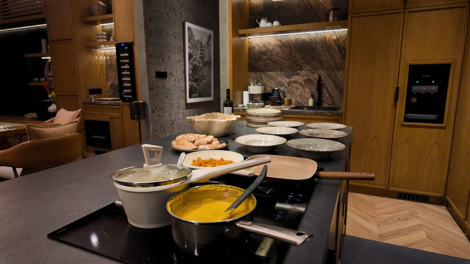 Pans and prepared dishes on the island of a villa kitchen